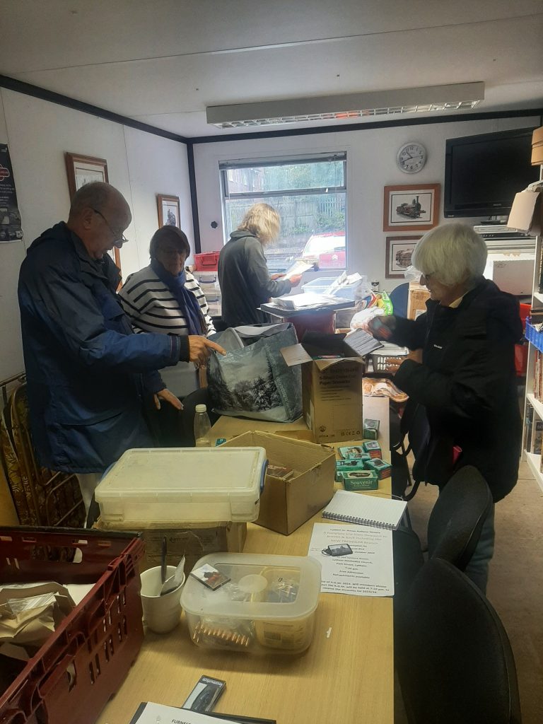 Phil Burton, Alison, Ade and Anne prepare the sales stand for the visit to Bury