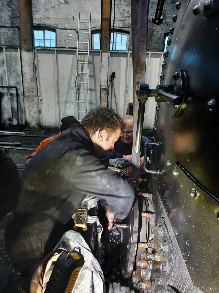 Matt Hainsworth refits the right hand cylinder cover on FR 20 on Saturday morning as Bill Beverage looks on.