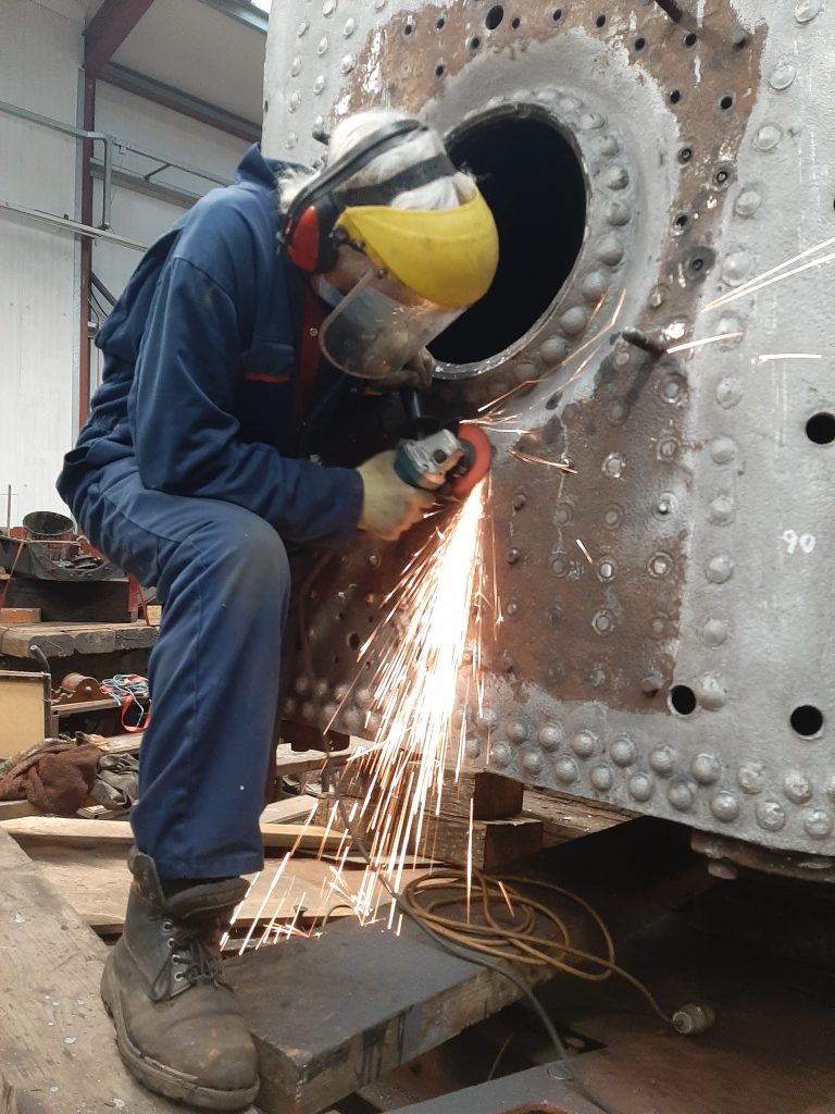 Ed Tatham grinding off more stay heads on 5643's firebox